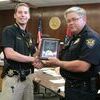 Arkansas County Sheriff's Deputy Taylor Roush receives a Life Saving Award plaque from Police Chief Jim Tucker.