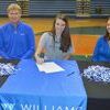 Libby Cox signs her letter of intent as her parents Harlan and Misty Cox look on.