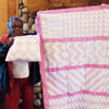 Maeola and her pink sample quilt top and pillow