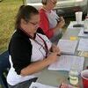 Marsha Sullivan and Nicole Ellenburg make sure the paperwork is properly filled out