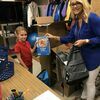 Avery helps DES Counselor, Lori Wilson stuff back packs
